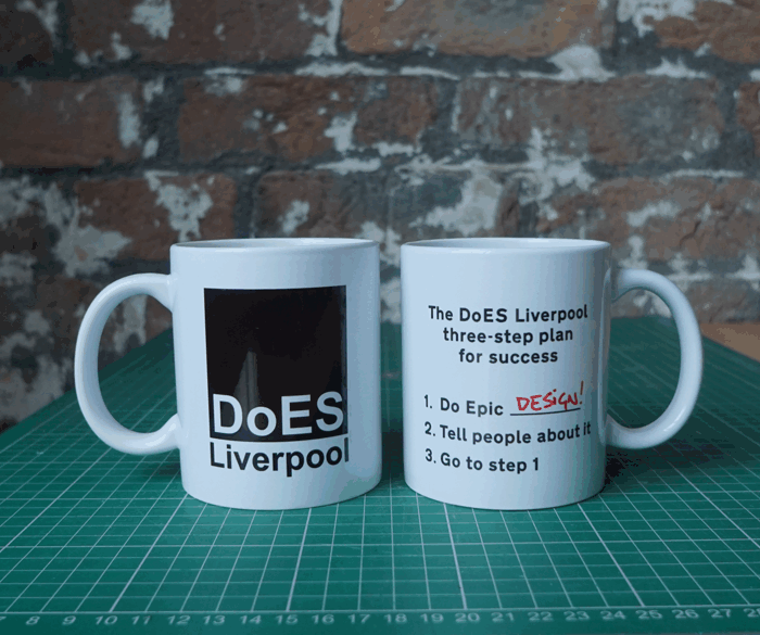 Two mugs on a table.  One shows the DoES Liverpool logo, and the other has a three-step plan for success: 1. Do epic _____; 2. Tell people about it; 3. Go to step 1.  It cycles through a list of epic step 1s: startups; CNC; meetups; design; research; art...