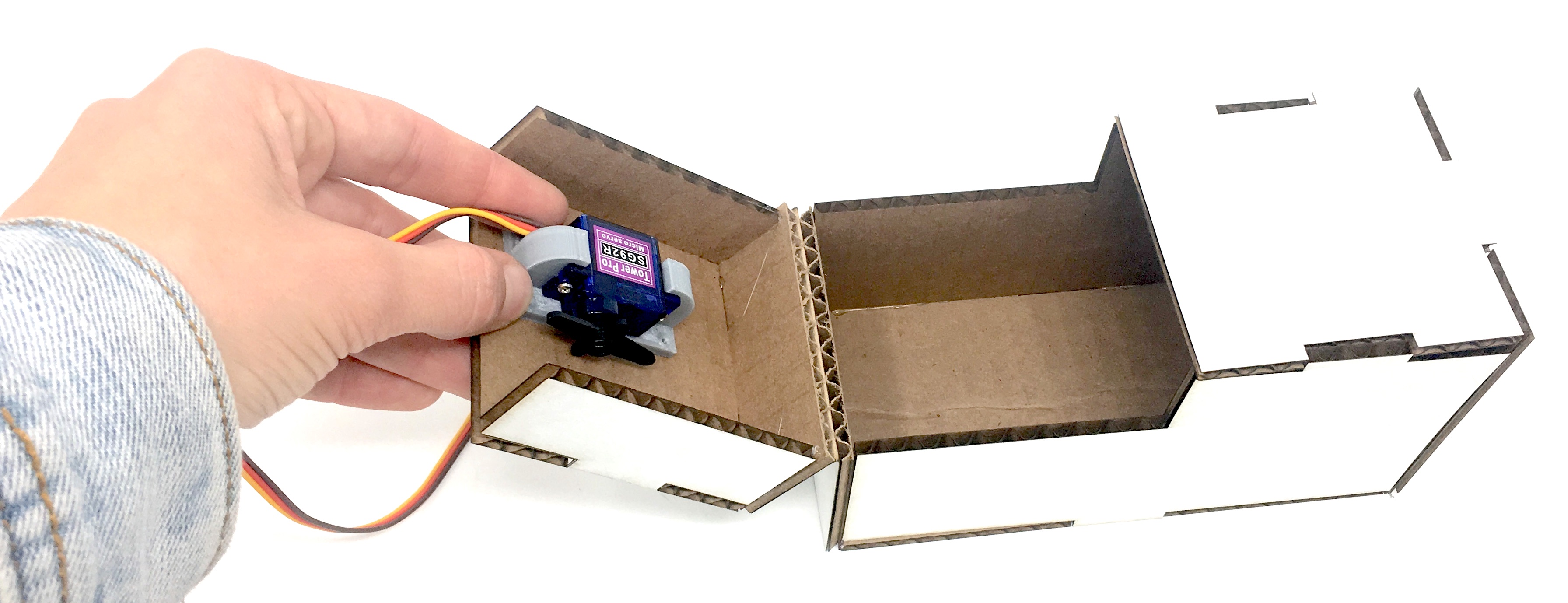 Laser cut box with Andrea holding servo on 3D-printed mount on the moving side of the box. Where should the Arduino be mounted?