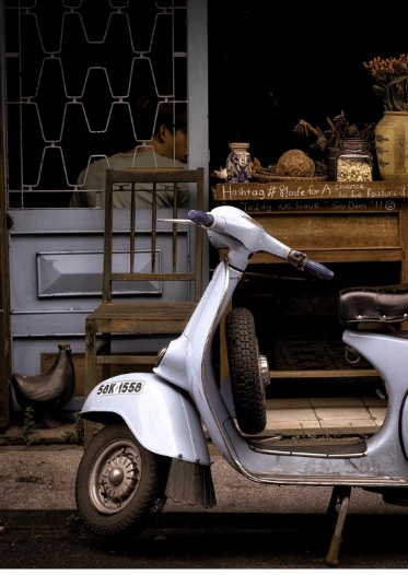 Vespa scooter parked on a street.