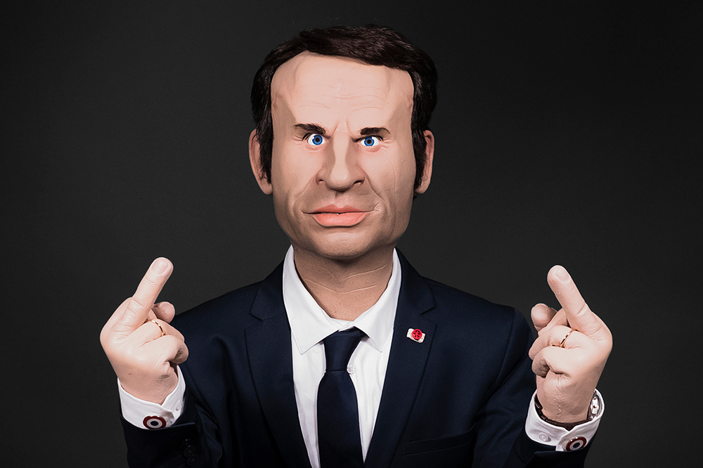 Photo d'une marionnette représentant Macron faisant des doigts d'honneur.