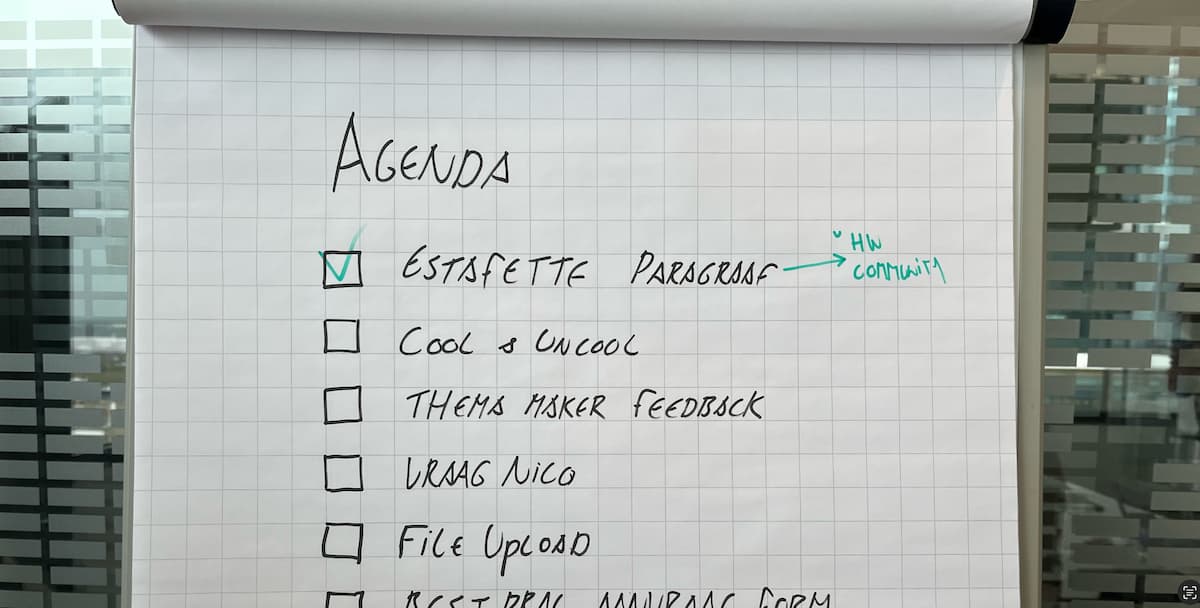 whiteboard met daarop de agenda, het eerste item, estafette paragrafa is afgevinkt, met toevoeging HW community, eronder staan nog meer items, namelijk cool uncool, thema maker feedback, vraag Nico, file upload