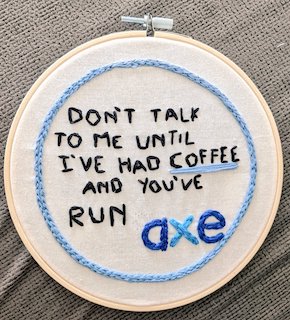 Embroidery that says "Don't talk to me until I've had coffee and you've run axe" in a hoop