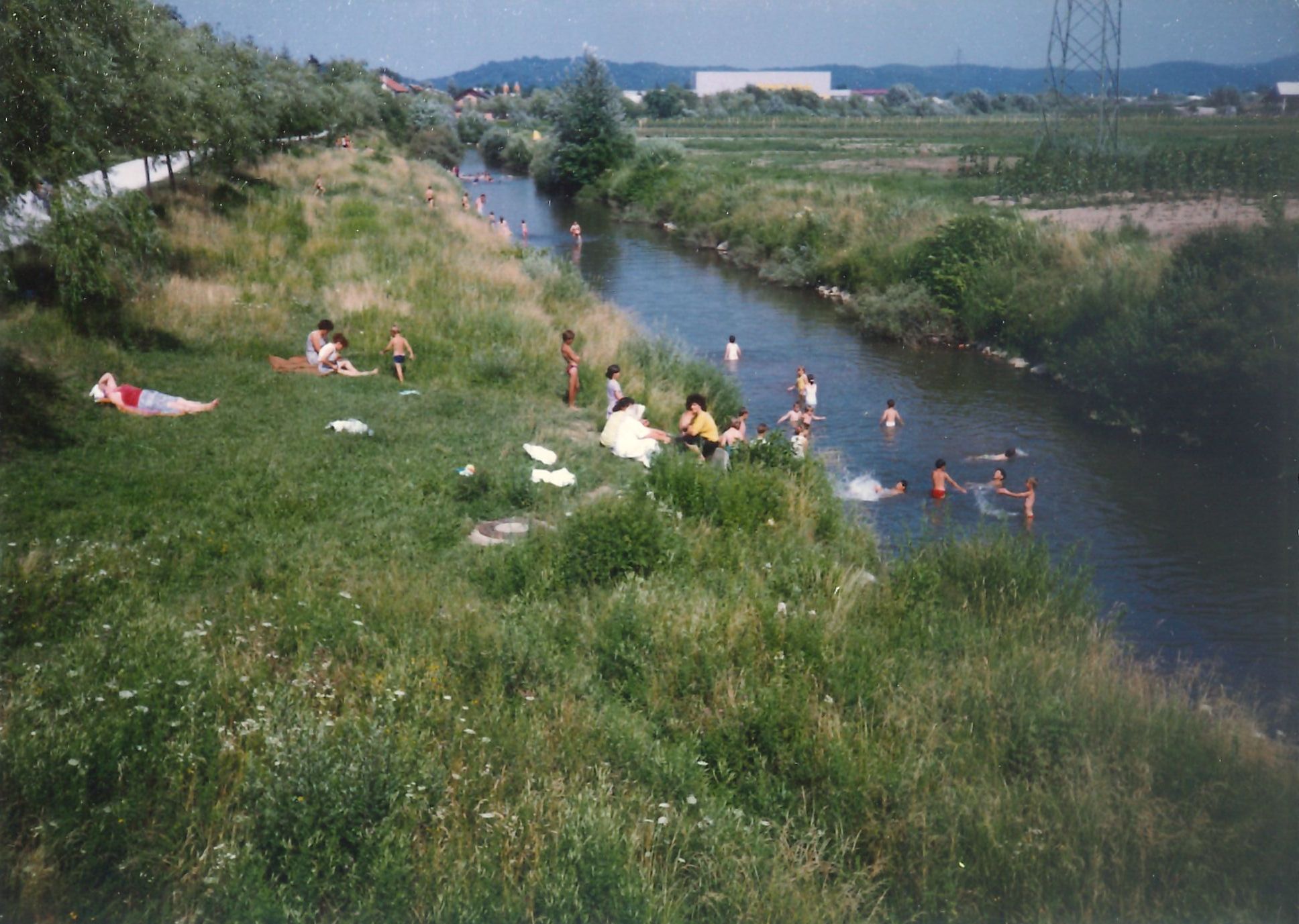Slika 6: Bosanski begunci med kopanjem v Malem grabnu v
                                Ljubljani 4. julija 1992. Foto: 
                     