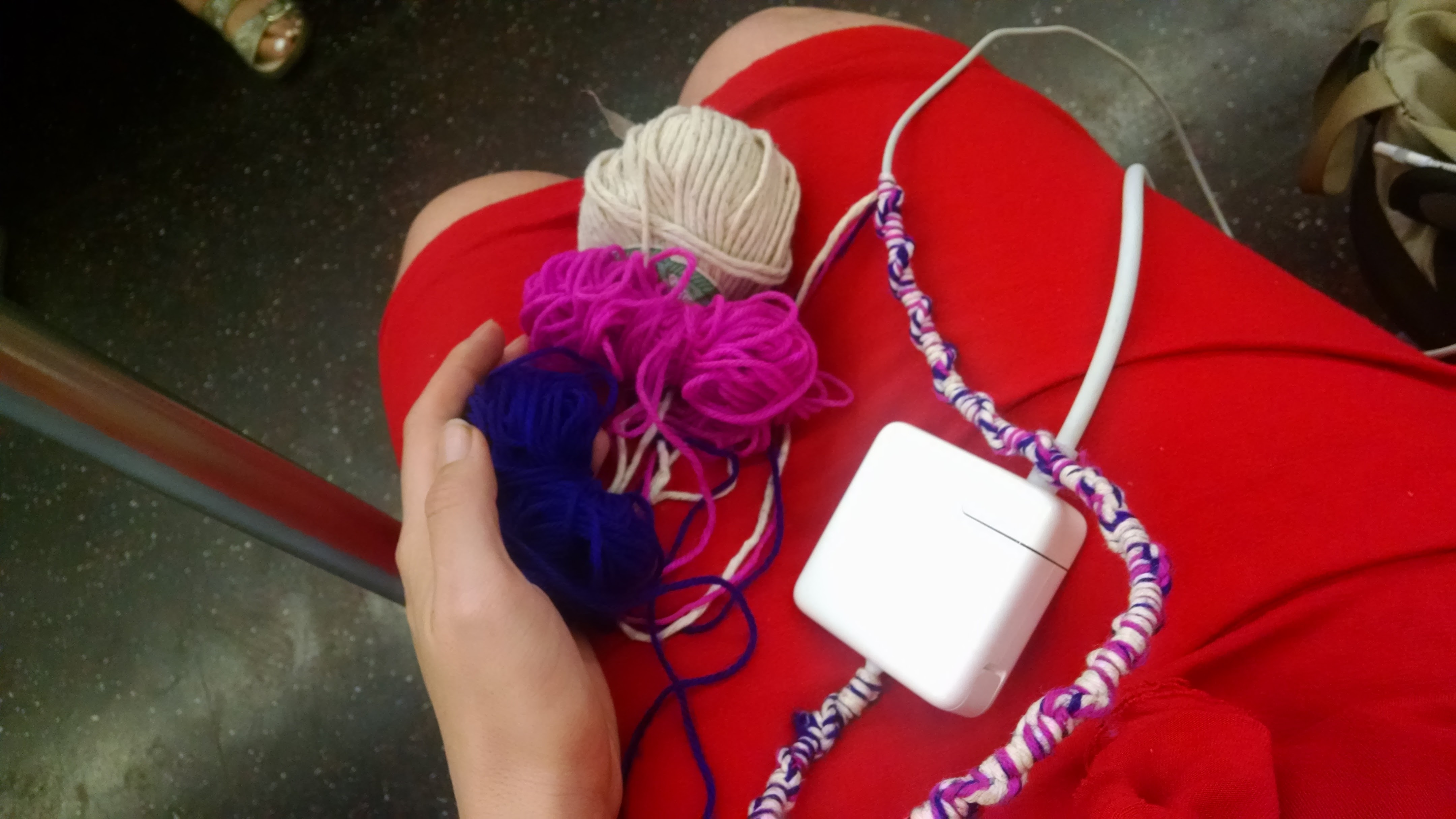 partly covered charger and balled yarn across my lap while I sit on the subway
